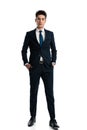 elegant young businessman in navy blue suit holding hands in pockets Royalty Free Stock Photo