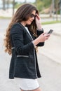 Young businesswoman with elegant clothes checking her phone: Selective focus. communication concept.