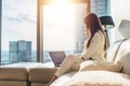 Elegant young female business woman using a laptop sitting on a sofa at home Royalty Free Stock Photo