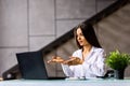 Elegant young woman business woman using a laptop sitting on a sofa at home Royalty Free Stock Photo