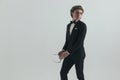 Elegant young groom in black tuxedo with bowtie looking over shoulder Royalty Free Stock Photo