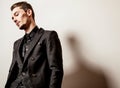 Elegant young handsome man in black costume. Studio fashion portrait.