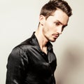 Elegant young handsome man in black silk shirt. Studio fashion portrait.