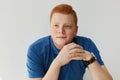 An elegant young handsome man with red hair and freckles wearing blue shirt and watch holding his hands together isolated over whi Royalty Free Stock Photo