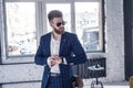 Elegant young handsome man with beard wearing glasses and watchers. Loft studio fashion portrait Royalty Free Stock Photo