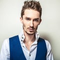 Elegant young handsome man in white shirt & vest. Studio fashion portrait.