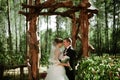 Elegant young happy wedding couple is sitting at green grass on Royalty Free Stock Photo