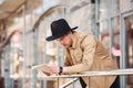 Elegant young man in formal classy clothes outdoors in the city reading newspaper Royalty Free Stock Photo