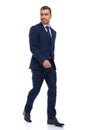 elegant young man in navy blue suit looking to side and smiling Royalty Free Stock Photo