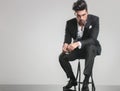 Elegant young man in tuxedo sitting on a stool Royalty Free Stock Photo