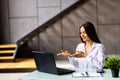 Elegant young woman business woman using a laptop sitting on a sofa at home Royalty Free Stock Photo
