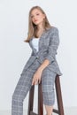 Elegant young woman in checkered suit posing