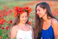 Elegant young woman with child girl in poppy field, happy family having fun in nature, summer time Royalty Free Stock Photo