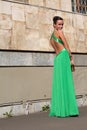 Elegant woman in green dress posing against a concrete wall Royalty Free Stock Photo
