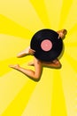 Elegant young woman with slim tanned body with vinyl on head against vivid yellow background. Contemporary art collage