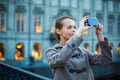 Elegant, young woman taking a photo with her cell phone camera Royalty Free Stock Photo