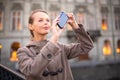 Elegant, young woman taking a photo with her cell phone camera Royalty Free Stock Photo