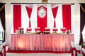 Elegantly catered wedding reception hall with red ribbons on lux