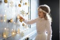 Elegantly dressed girl of 8-9 years with delight touches gold Christmas garlands Royalty Free Stock Photo