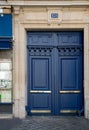 Elegat navy blue painted antique framed door of old building in Paris France. Matte painted wooden door panels