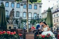 Elegent newlywed couple is holding hands and touching heads while sitting at the otdoor wooden table. Beautiful nature