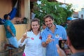 Man and woman pose for a photo making an L with their hands.