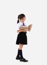 Elemantary school girl in student uniform holding and reading book on white background. Back to school