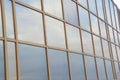 Glass facade of a modern building. The sky reflected in the windows of an office building. Element of architecture Royalty Free Stock Photo