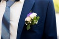 The element of the groom`s blue suit with a blue necktie and Boutonniere in his jacket pocket Royalty Free Stock Photo