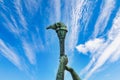Element of a stone monument a torch in hand on the backdrop of a beautiful sky. A symbol of light and progress Royalty Free Stock Photo