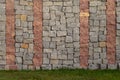 Element of the wall from blocks of gray and red granite. Near the green lawn. Royalty Free Stock Photo