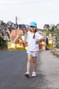 Elementary age child, school age girl walking through a small town alone, taking a walk, street stroll, rural area, one person Royalty Free Stock Photo