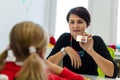 Elementary Age Girl in Child Occupational Therapy Session Doing Playful Exercises With Her Therapist. Royalty Free Stock Photo