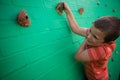 Elementary boy climbing on brick wall Royalty Free Stock Photo