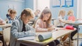 Elementary Classroom of Diverse Children Writing in Exercise Notebooks, Taking Tests, Exams. Brill Royalty Free Stock Photo