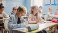 Elementary Classroom of Diverse Children Writing in Exercise Notebooks, Taking Tests, Exams. Brill Royalty Free Stock Photo