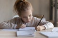 Little preteen girl study foreign language writing classwork at desk