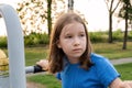 Elementary school age child on a playground outdoors, simple natural serious portrait face closeup Caucasian European Polish girl