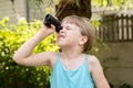Elementary school age girl looking up into the sky through a magnifying monocular watching birds, searching, seeking, looking for
