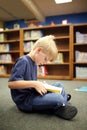 Elementary School Aged Child Reading Book at Library