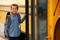 Elementary school boy getting onto a yellow school bus Royalty Free Stock Photo