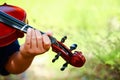 Elementary school boy Playing violin in the garden Royalty Free Stock Photo