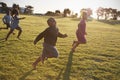 Elementary school boys and girls running in an open field