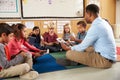 Elementary school class sitting cross legged using tablets Royalty Free Stock Photo