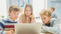 Elementary School Classroom: Diverse Group of Brilliant Children Using Laptop Computer for Softwar Royalty Free Stock Photo