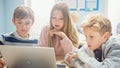 Elementary School Classroom: Diverse Group of Brilliant Children Using Laptop Computer for Softwar