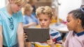 Elementary School Computer Science Class: Two Girls and Boy Use Digital Tablet Computer with Royalty Free Stock Photo