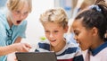 Elementary School Computer Science Class: Two Girls and Boy Use Digital Tablet Computer with Royalty Free Stock Photo