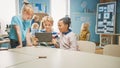 Elementary School Computer Science Class: Two Girls and Boy Use Digital Tablet Computer with Royalty Free Stock Photo
