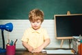 Elementary school and education - school concept. Kid with a book. Funny little child having fun on blackboard Royalty Free Stock Photo